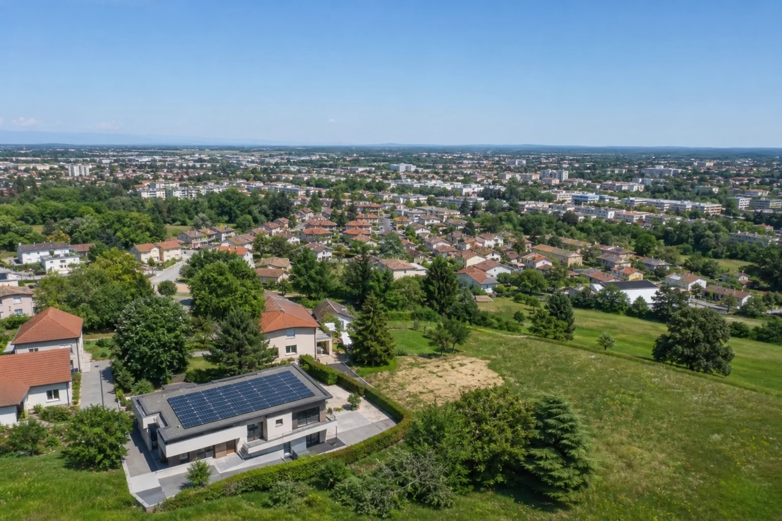 Vue aérienne d’un quartier de l’Ain avec une maison solaire
